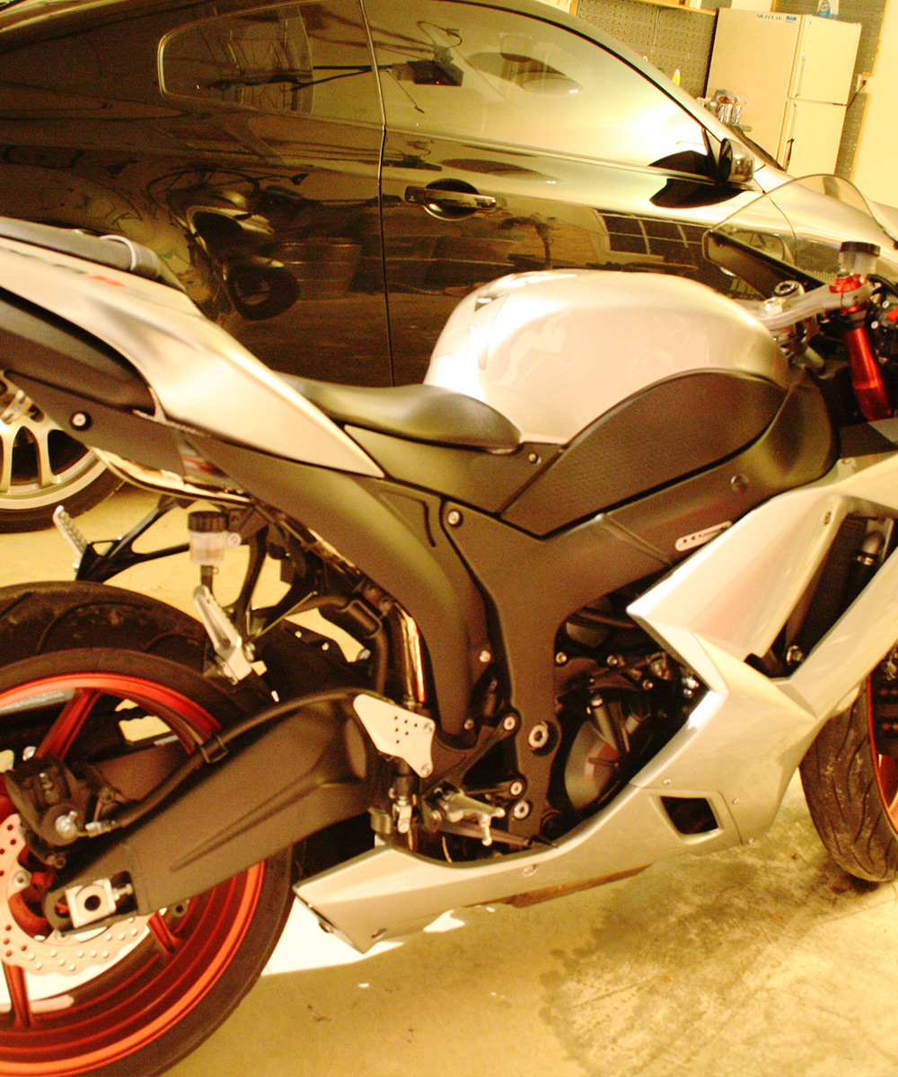 A street bike in a Client's garage next to a black Infiniti G35