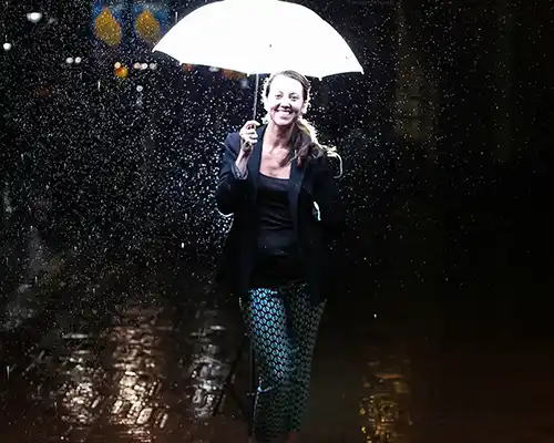Shannon Springer standing in the rain under a brightly lit umbrella in Charlottesville Virginia
