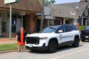 A smiling Peggy with the new company Car